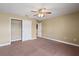 This bedroom has neutral walls and carpet with closet access and a ceiling fan at 2412 Country Pond Ct, St Cloud, FL 34771