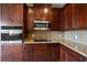 Beautiful kitchen boasts granite counters, stainless appliances, and rich dark wood cabinetry at 2412 Country Pond Ct, St Cloud, FL 34771