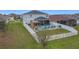 Aerial shot of a home's spacious backyard with a pool, patio, lanai, and white picket fence at 2473 Biscotto Cir, Davenport, FL 33897