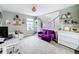 Stylish bedroom with a gray carpet, vibrant purple sofa, work desk, and a window offering natural light at 2473 Biscotto Cir, Davenport, FL 33897