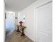 Bright hallway features a wooden accent table with a mirror above it and neutral colored carpet at 2473 Biscotto Cir, Davenport, FL 33897