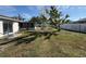 Large backyard featuring a white fence, grass, and an outdoor seating area at 268 Florida Pkwy, Kissimmee, FL 34743
