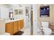 Bright bathroom with a double vanity, wood cabinets, and a view into another room at 3686 Ricky Ln, St Cloud, FL 34772