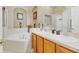 Bathroom featuring dual vanities, a soaking tub, a stand-up shower, and neutral tones at 3686 Ricky Ln, St Cloud, FL 34772