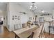 Dining room with a wooden table, upholstered chairs, a chandelier and a view into the kitchen at 3686 Ricky Ln, St Cloud, FL 34772