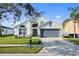 Inviting single-story home with a two-car garage, lush lawn, and decorative landscaping at 3686 Ricky Ln, St Cloud, FL 34772
