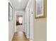 Hallway with wood-look floors leading to bedroom with natural light and neutral paint at 3686 Ricky Ln, St Cloud, FL 34772