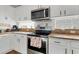 Bright kitchen featuring white cabinets, stainless steel appliances, and granite countertops at 3686 Ricky Ln, St Cloud, FL 34772