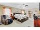 Spacious main bedroom featuring a ceiling fan, large bed, recliner, and ample natural light at 3686 Ricky Ln, St Cloud, FL 34772