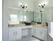 Bright bathroom featuring a double vanity, a large mirror, and contemporary sconces at 4301 Presidio Way, Kissimmee, FL 34746