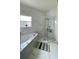 Beautiful bathroom featuring marble-like tile, soaking tub, and separate glass shower with built-in shelving at 4301 Presidio Way, Kissimmee, FL 34746
