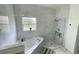 Bathroom featuring marble-like tile, soaking tub, and separate glass shower with built-in shelving at 4301 Presidio Way, Kissimmee, FL 34746