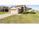 Charming home featuring a well-manicured lawn and attached two-car garage at 4301 Presidio Way, Kissimmee, FL 34746