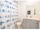 Cozy bathroom featuring a bird-themed shower curtain, a white toilet, and a vanity with gray cabinets at 4479 Blue Rock Dr, Sanford, FL 32771