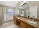 Primary bathroom with double sinks, granite counters, soaking tub, and glass shower at 4614 Falcon Ave, Kissimmee, FL 34746