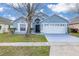 Charming blue single Gathering home with a well-manicured lawn and a two-car garage at 4614 Falcon Ave, Kissimmee, FL 34746