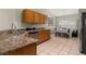 Well-lit kitchen featuring granite countertops, stainless steel appliances, and wooden cabinets at 4614 Falcon Ave, Kissimmee, FL 34746
