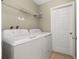 Functional laundry room featuring a washer, dryer, shelving, and ample space at 4614 Falcon Ave, Kissimmee, FL 34746