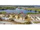 Aerial view of townhomes near a tranquil lake, surrounded by lush greenery and beautiful landscaping at 486 Lake Shore Pkwy, Davenport, FL 33896