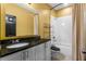 Bathroom boasts a vanity with black granite countertop, toilet and shower-tub combination at 486 Lake Shore Pkwy, Davenport, FL 33896