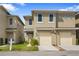 Inviting townhome with neutral stucco exterior, attached garages, well-manicured lawns, and stone walkways at 486 Lake Shore Pkwy, Davenport, FL 33896