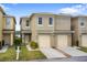 Inviting townhome showcasing a well-kept lawn and an attached one-car garage at 486 Lake Shore Pkwy, Davenport, FL 33896
