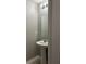 Powder room featuring a pedestal sink, mirror and modern light fixture at 49 Inconnu Dr, Poinciana, FL 34759