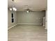 Open-concept living room with gray walls, modern ceiling fan and light wood floors at 49 Inconnu Dr, Poinciana, FL 34759