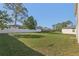 Expansive backyard featuring lush green grass and a secure white privacy fence at 49 Inconnu Dr, Poinciana, FL 34759
