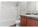 Bright bathroom features a tub/shower combo, dark wood vanity, and light gray walls at 49 Inconnu Dr, Poinciana, FL 34759