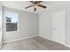 Well-lit bedroom featuring a ceiling fan, plush carpet, and a window with neighborhood views at 49 Inconnu Dr, Poinciana, FL 34759