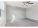 This bedroom has light grey walls and plush carpeting and a ceiling fan at 49 Inconnu Dr, Poinciana, FL 34759