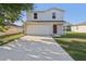 Two-story home featuring attached garage, driveway, landscaped yard, and a red front door at 49 Inconnu Dr, Poinciana, FL 34759