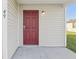 Close-up of the red front door, providing a welcoming entrance to the home at 49 Inconnu Dr, Poinciana, FL 34759