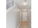 Hallway with light wood floors leading to white door, freshly painted gray walls, and modern lighting at 49 Inconnu Dr, Poinciana, FL 34759