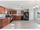 A kitchen with wooden cabinets, laminate countertops, black appliances, gray walls and light gray flooring at 49 Inconnu Dr, Poinciana, FL 34759