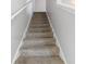 Carpeted staircase with white railing, leading to the upper level of the home at 49 Inconnu Dr, Poinciana, FL 34759