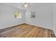 Cozy bedroom with wood-look flooring, neutral walls, and bright natural light from two windows at 495 Orange Ave, St Cloud, FL 34769
