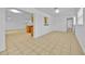 Bright living room featuring tile flooring, white walls, and a pass-through to the kitchen at 495 Orange Ave, St Cloud, FL 34769