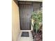Secure black metal front door, complemented by a decorative mat and mature landscaping at 502 Polaris Loop # 110, Casselberry, FL 32707