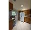 Functional kitchen featuring wood cabinets, white appliances, tile floors, and ample counter space at 502 Polaris Loop # 110, Casselberry, FL 32707