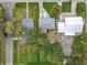 Aerial view of the property surrounded by mature trees, with houses nearby featuring green lawns at 521 Florida Ave, St Cloud, FL 34769