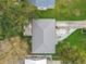 Aerial view of a house with a metal roof, showcasing the driveway, backyard, and surrounding greenery at 521 Florida Ave, St Cloud, FL 34769