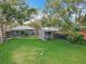 Spacious backyard featuring a large green lawn, storage shed, and patio, ideal for entertaining and leisure at 521 Florida Ave, St Cloud, FL 34769