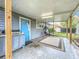 Relaxing covered patio with blue door, comfortable seating, and outdoor grill area at 521 Florida Ave, St Cloud, FL 34769