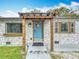 Close-up of the front exterior with stone accents, pergola and a bright blue door at 521 Florida Ave, St Cloud, FL 34769