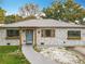 Charming exterior featuring a metal roof, stone accents, and a welcoming blue front door at 521 Florida Ave, St Cloud, FL 34769