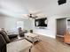 Comfortable living room featuring hardwood floors, a ceiling fan, and a large flat-screen TV at 521 Florida Ave, St Cloud, FL 34769