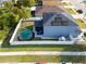 Aerial view of a fenced yard with an above ground pool, screened patio, and solar panels on the roof at 5640 Silver Thistle Ln, St Cloud, FL 34772