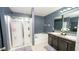 Bathroom featuring a bathtub, glass enclosed shower, and double sink vanity at 5640 Silver Thistle Ln, St Cloud, FL 34772